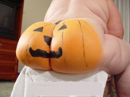 A man's huge butt painted like a pumpkin